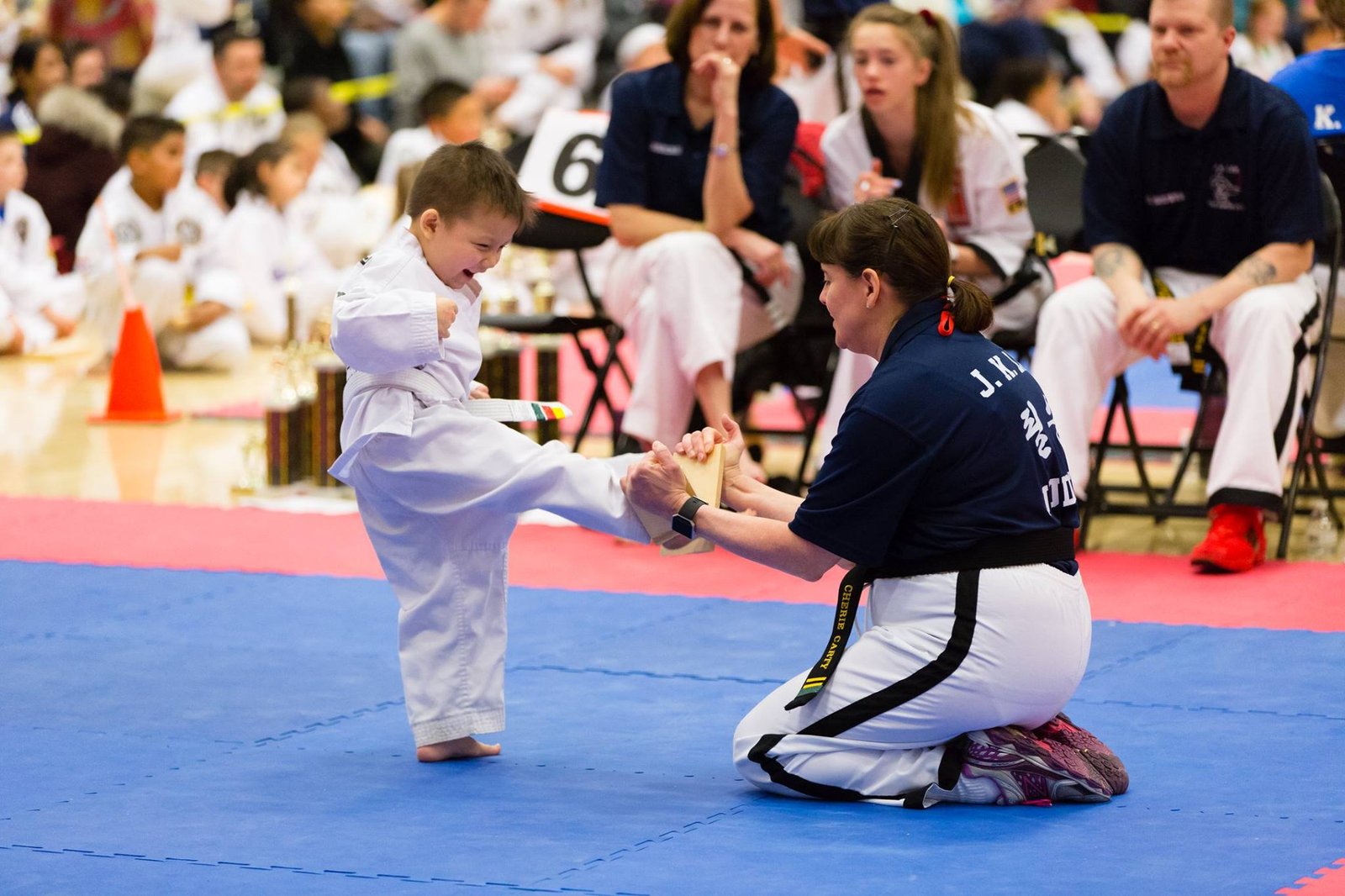 JK Lee instructor coaching a young student through a board break