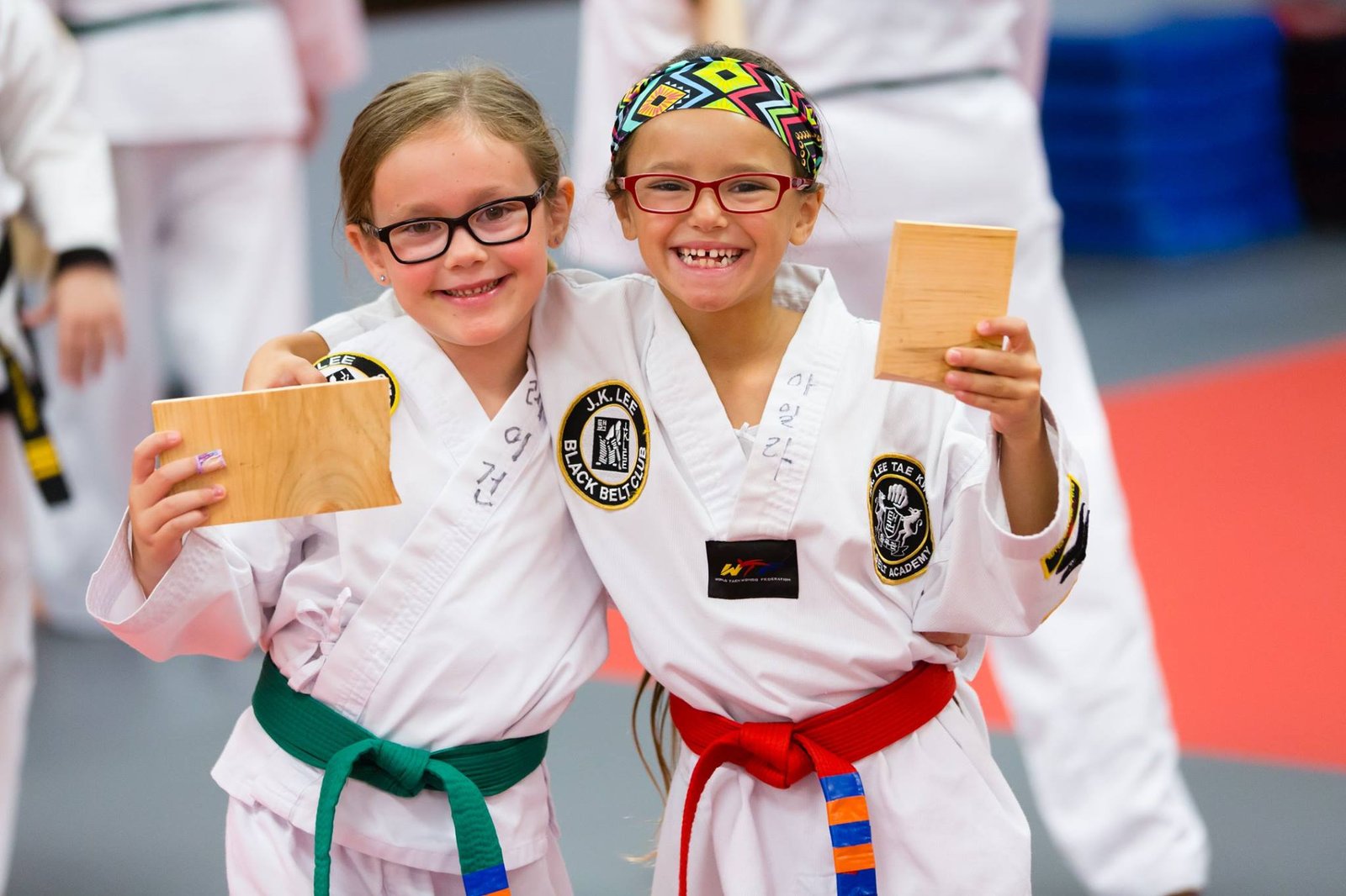 Two JK Lee students smiling proudly with broken boards after testing